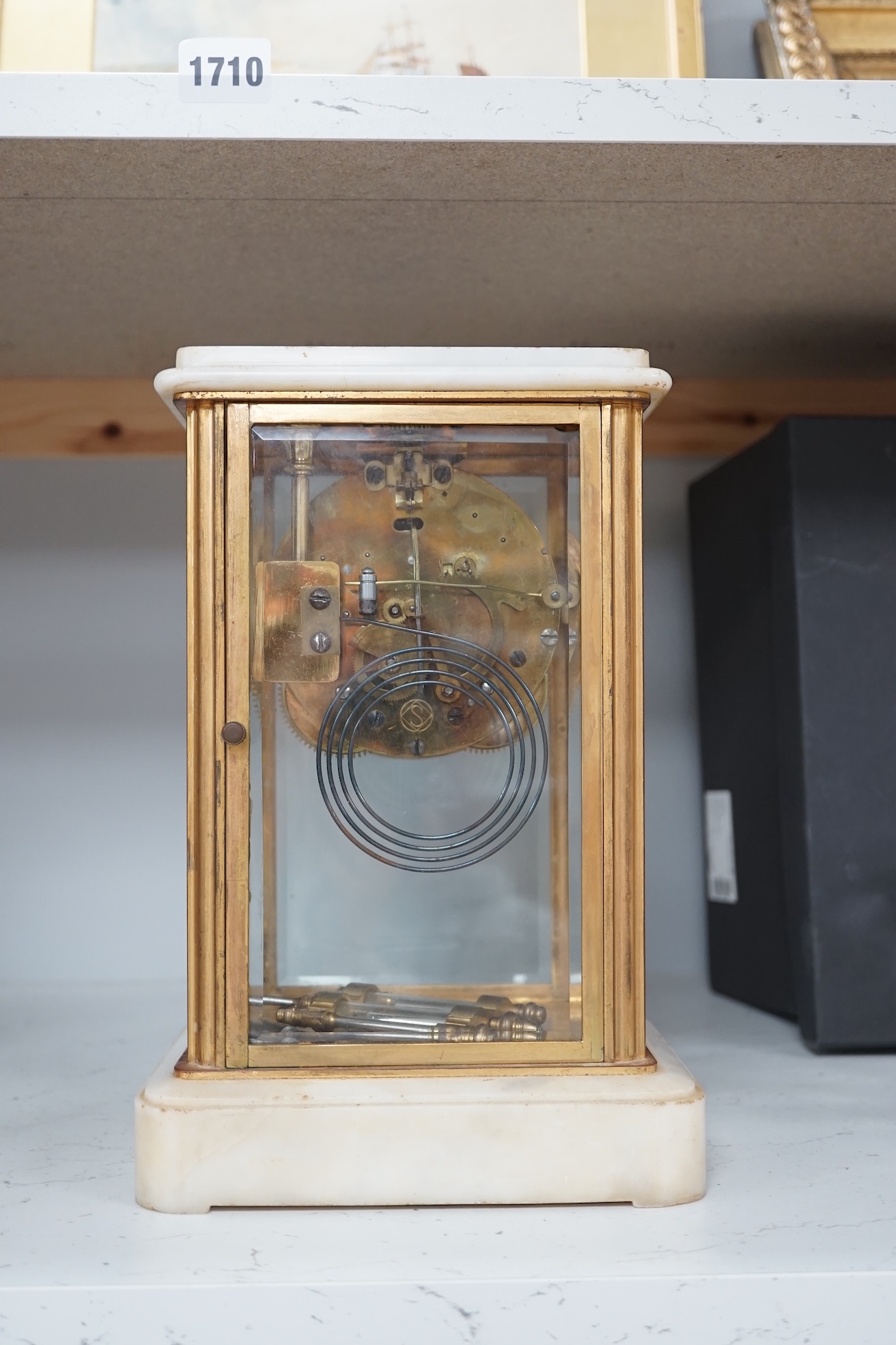 A Japanese four glass brass and alabaster mantel clock by Seikosha, with brocot type escapement and outside rack strike, striking on a coiled gong, height 27.5cm. Condition - fair to good.